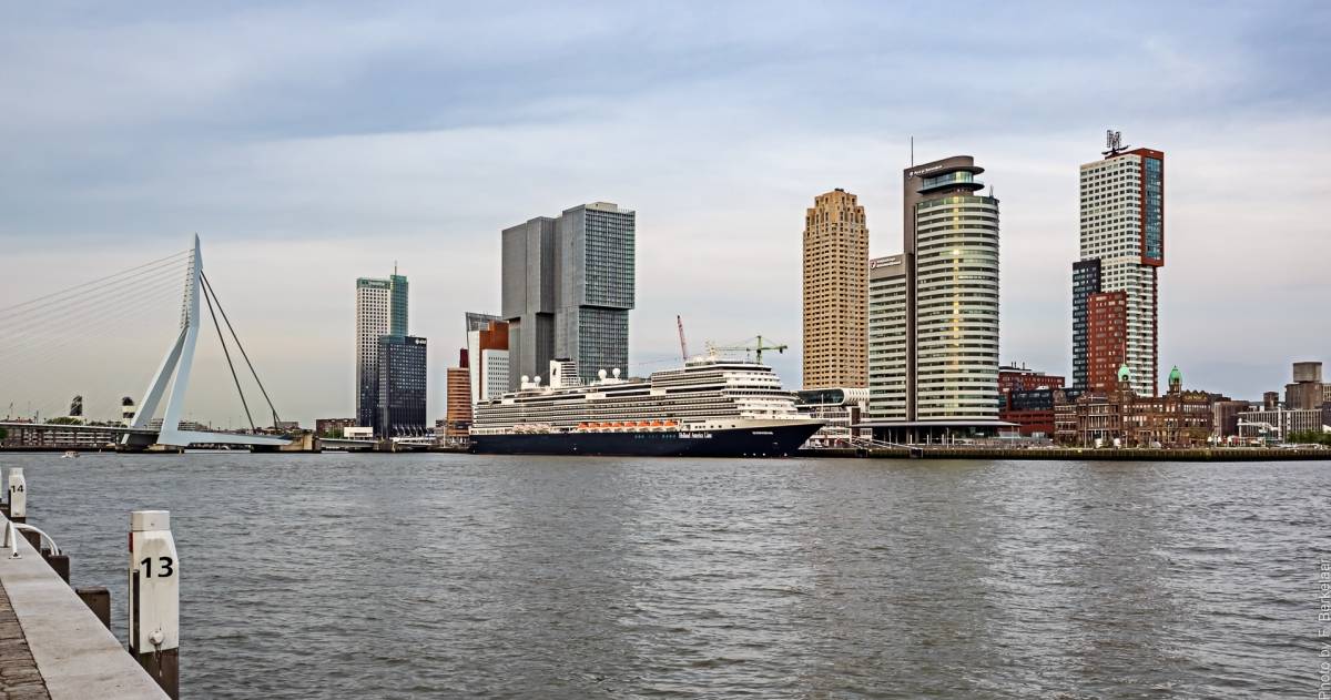 De erasmusbrug van Rotterdam met enkele gebouwen, water en een boot